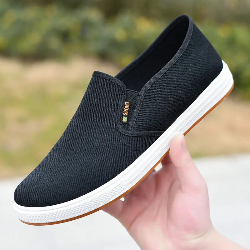 Men's low-top canvas slip-on shoes with rounded toe and injection moulded soles in black and blue colour options
