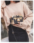Structured hard PU women's shoulder bag with a flap, hasp closure, and adjustable strap.