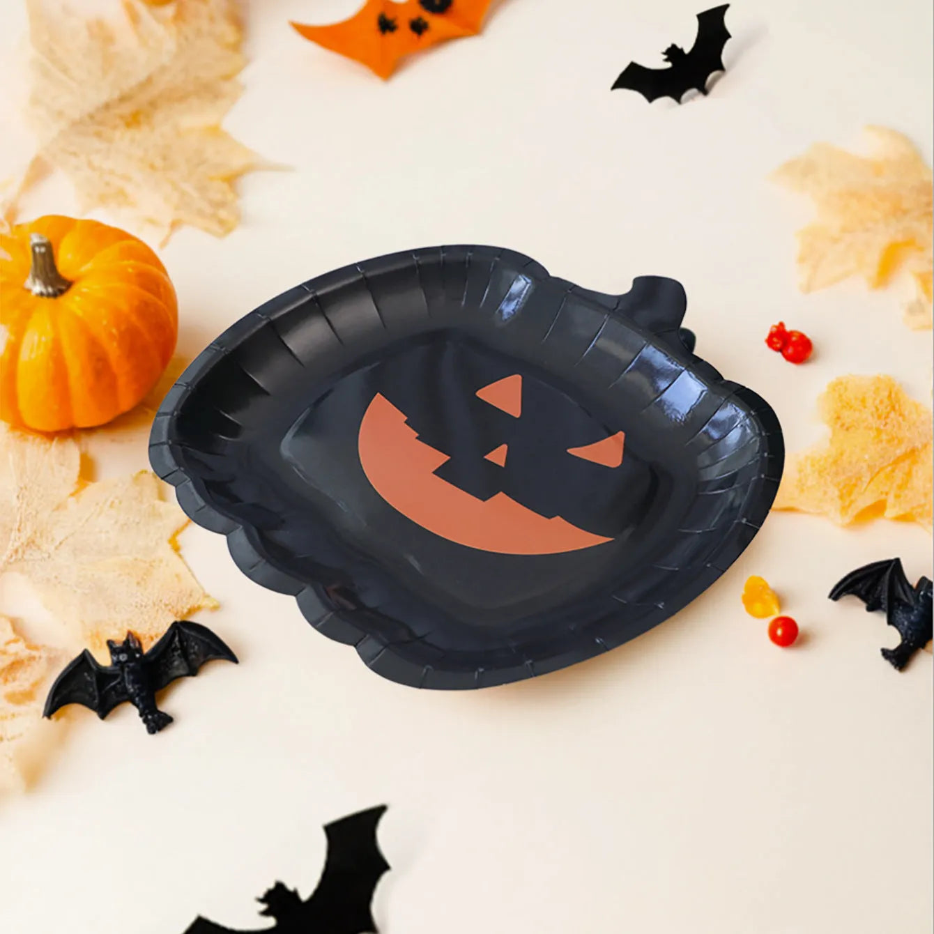 Black Halloween disposable paper plates with pumpkin designs, 9-inch diameter