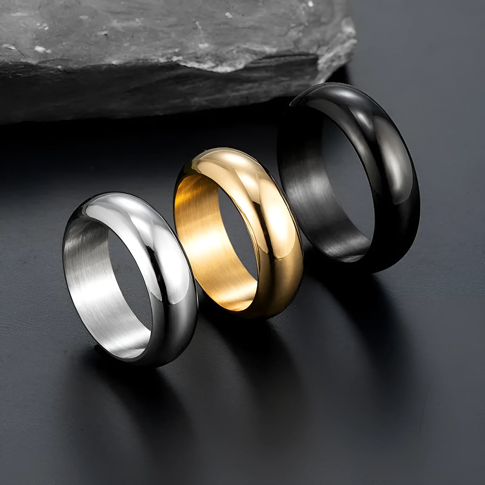 A glossy electroplated titanium steel ring in a gold colour, shown on a finger.