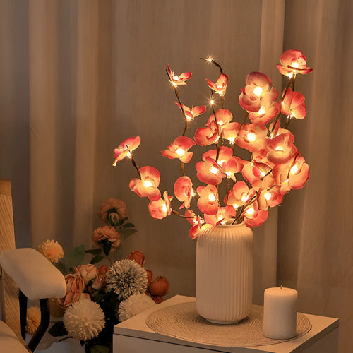 Pink phalaenopsis orchid branch decorative light with 20 LEDs, standing 65cm tall on a table.