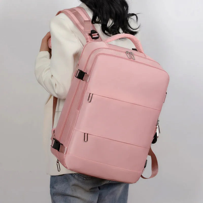 Large purple travel backpack with multiple compartments open, showing laptop sleeve and organiser pockets.