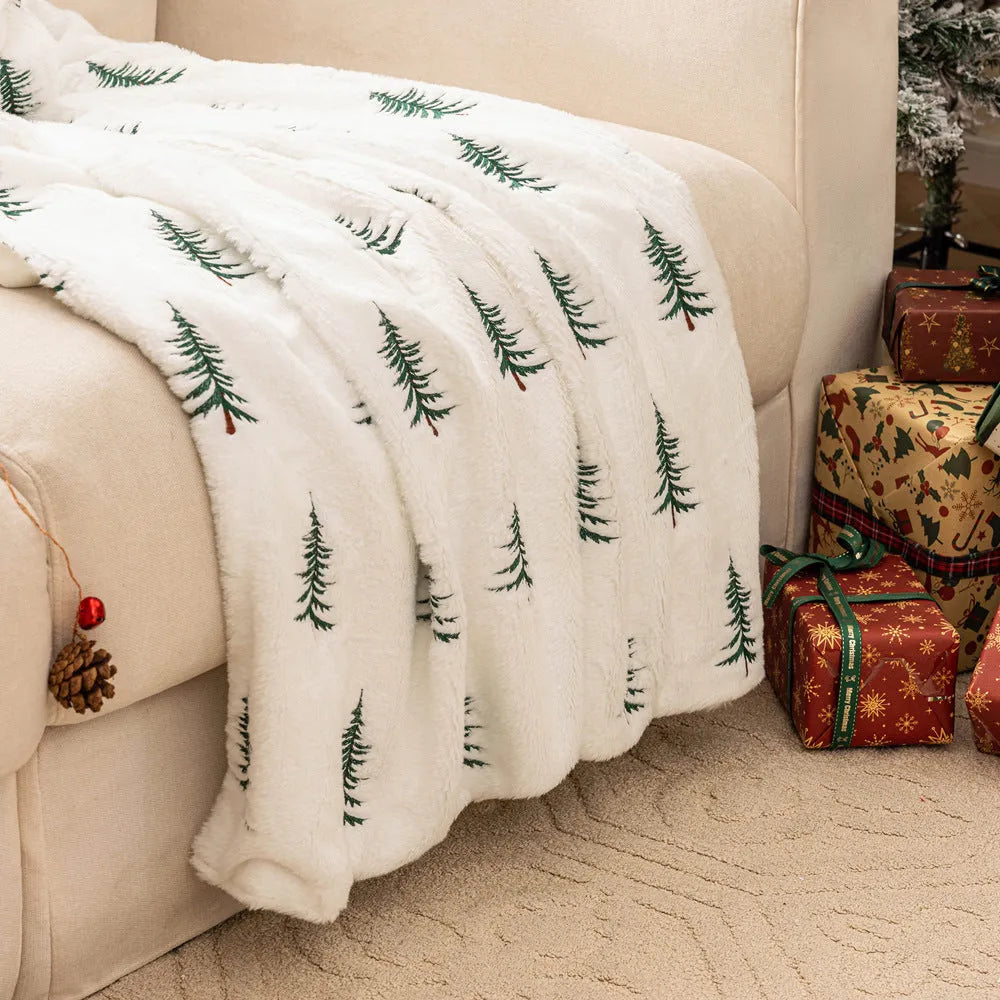 White polyester Christmas plush sofa blanket with embroidered Christmas tree design on a sofa