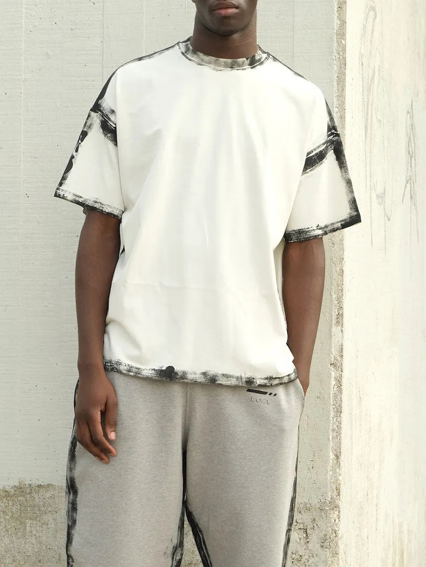 White casual short sleeve top with a draped print design on a hanger.