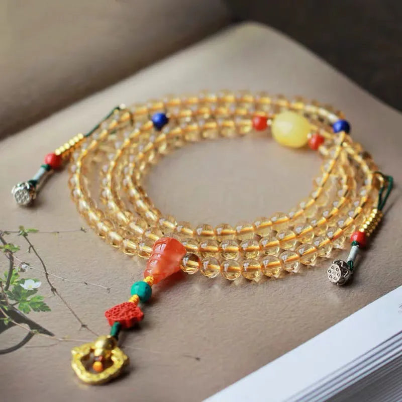 Close-up of a yellow Brazilian citrine bracelet with small 1mm beads on a black filament cord.