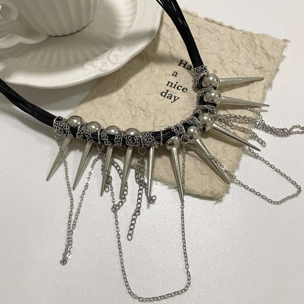 Leather necklace with electroplated round beads, winding design, tassel, and point rivet details.