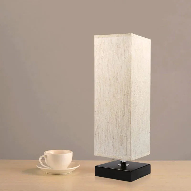 Modern square cloth covered table lamp with E26 socket on a wooden desk