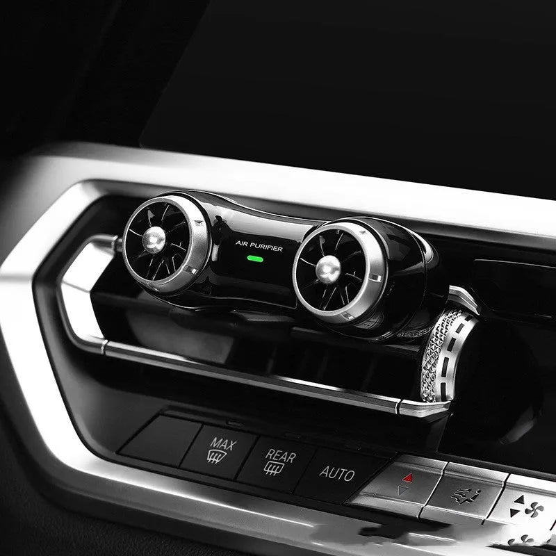 Compact black or white car air purifier with anion and aromatherapy functions for vehicle use.