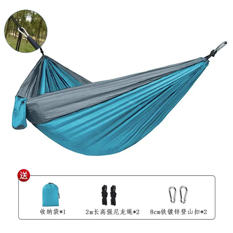Sapphire blue parachute nylon camping hammock hung between two trees, showing its full 270cm length.