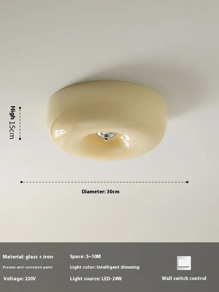 Creamy yellow and white opal shade ceiling light with remote control on a bedroom ceiling.