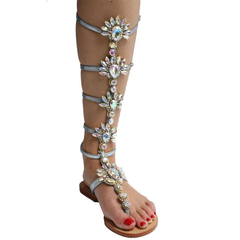 Women's flat roman sandals with rhinestone upper, round toe, in silver colour on plain background