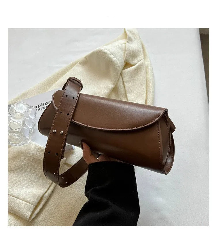 PU leather cylinder crossbody bag in black, horizontal square shape with crossbody strap
