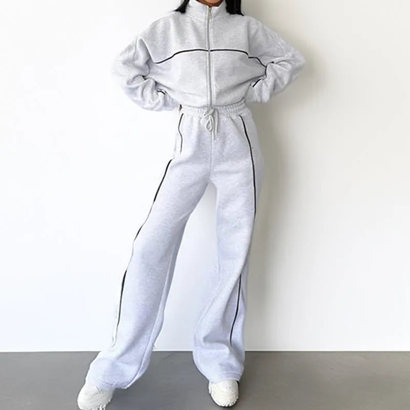 Casual polyester suit set showing a long sleeve mock neck hoodie and striped trousers on a model.
