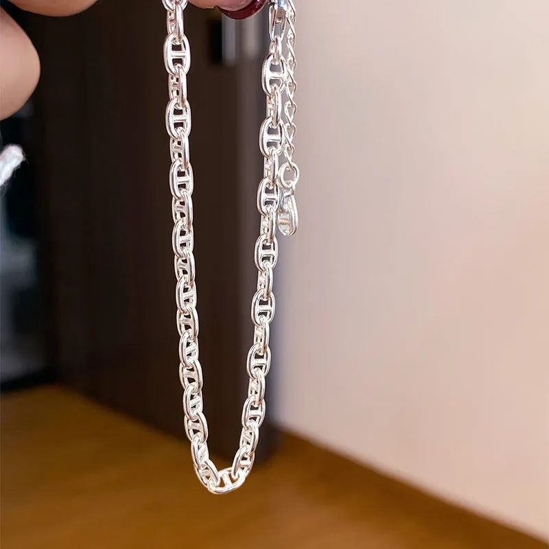 Minority stackable bracelet in polished 925 sterling silver pig nose chain style on white background