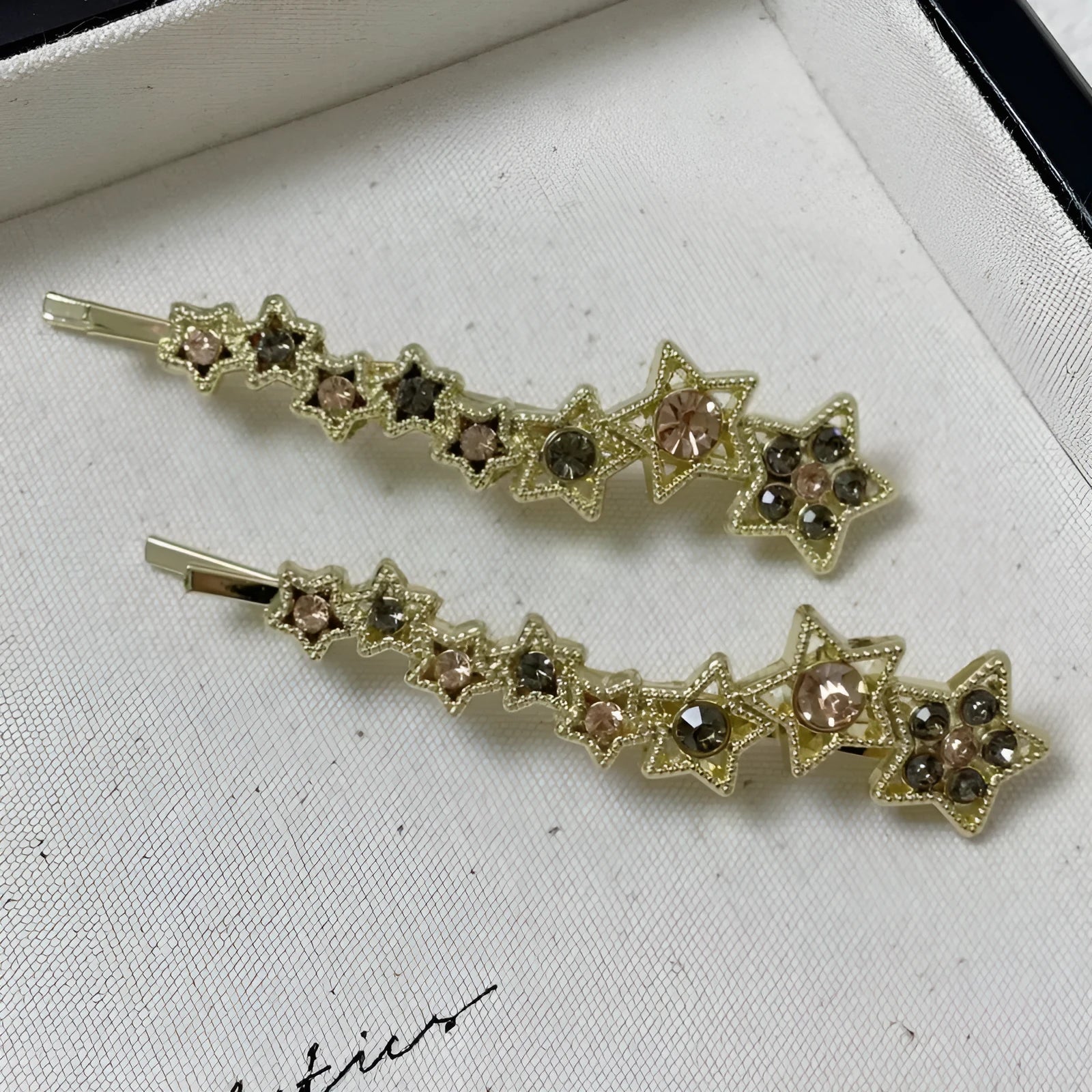 Gold-coloured alloy hair barrette with a rhinestone five-pointed star, shown as a side clip.