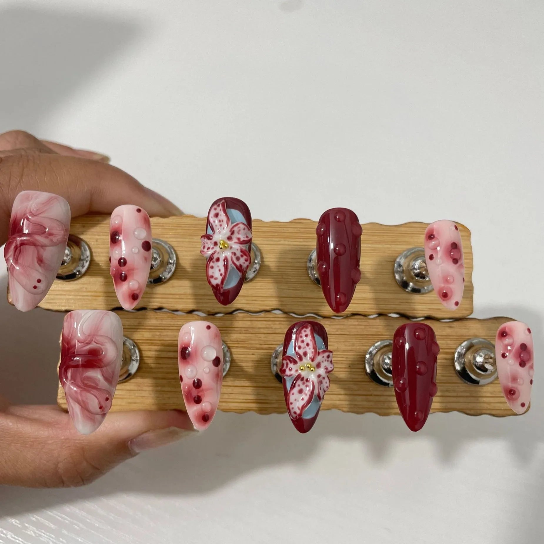 Hand-painted 3D sculpted press-on false nails with multiple patterns in almond shape