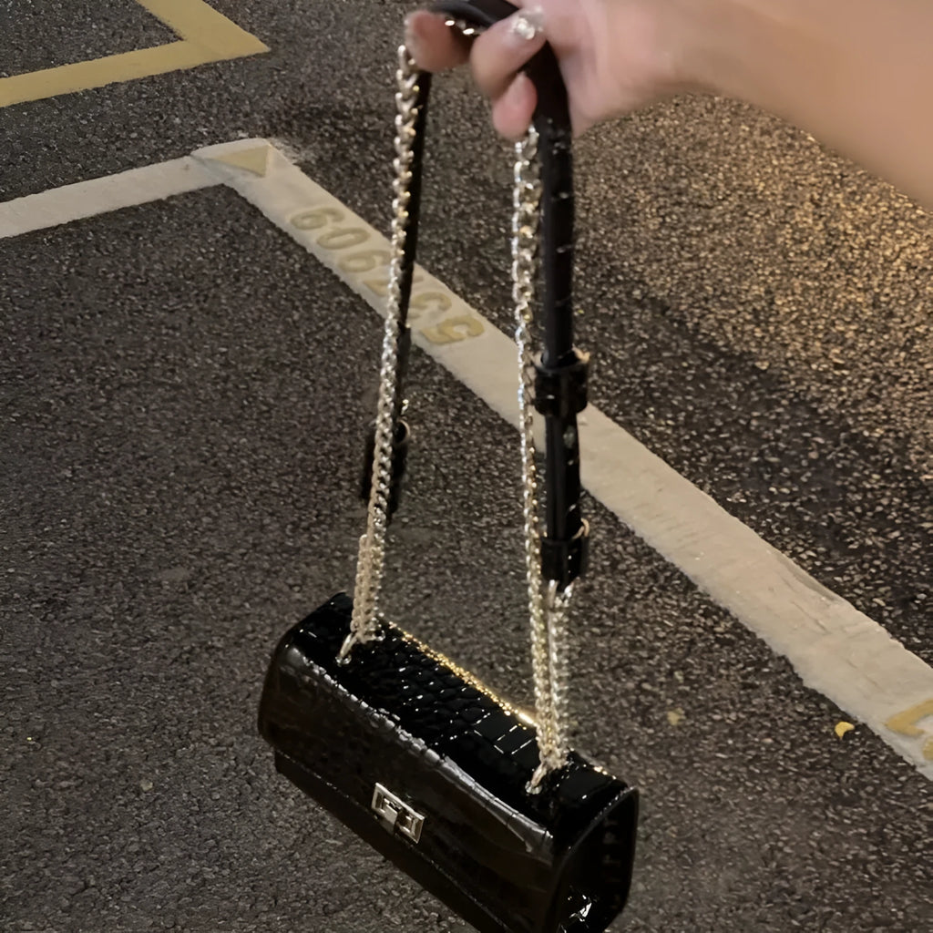 Black polyester fibre crossbody bag with chain strap, bow tie accent, and small square shape for everyday commuting