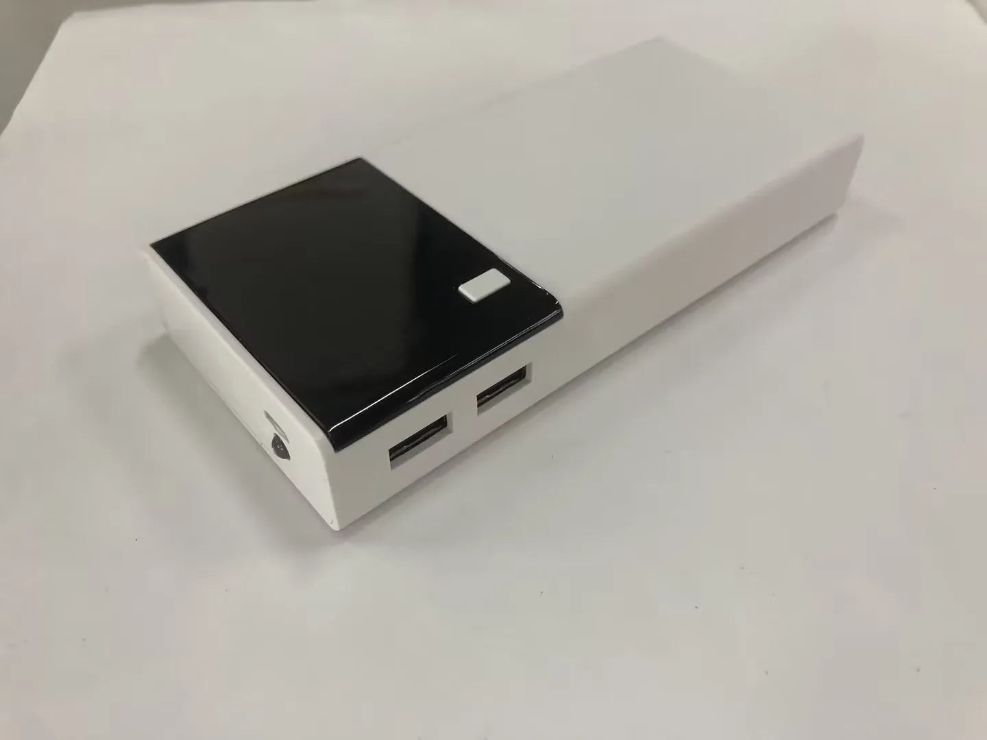 Black 20000mAh portable power bank with USB charging cable on a white background.
