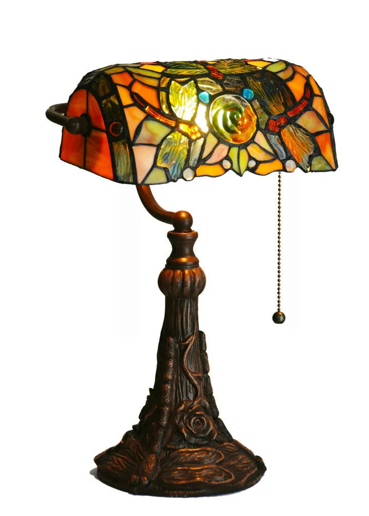 Tiffany-style table lamp with colourful stained glass shade and resin base on a desk