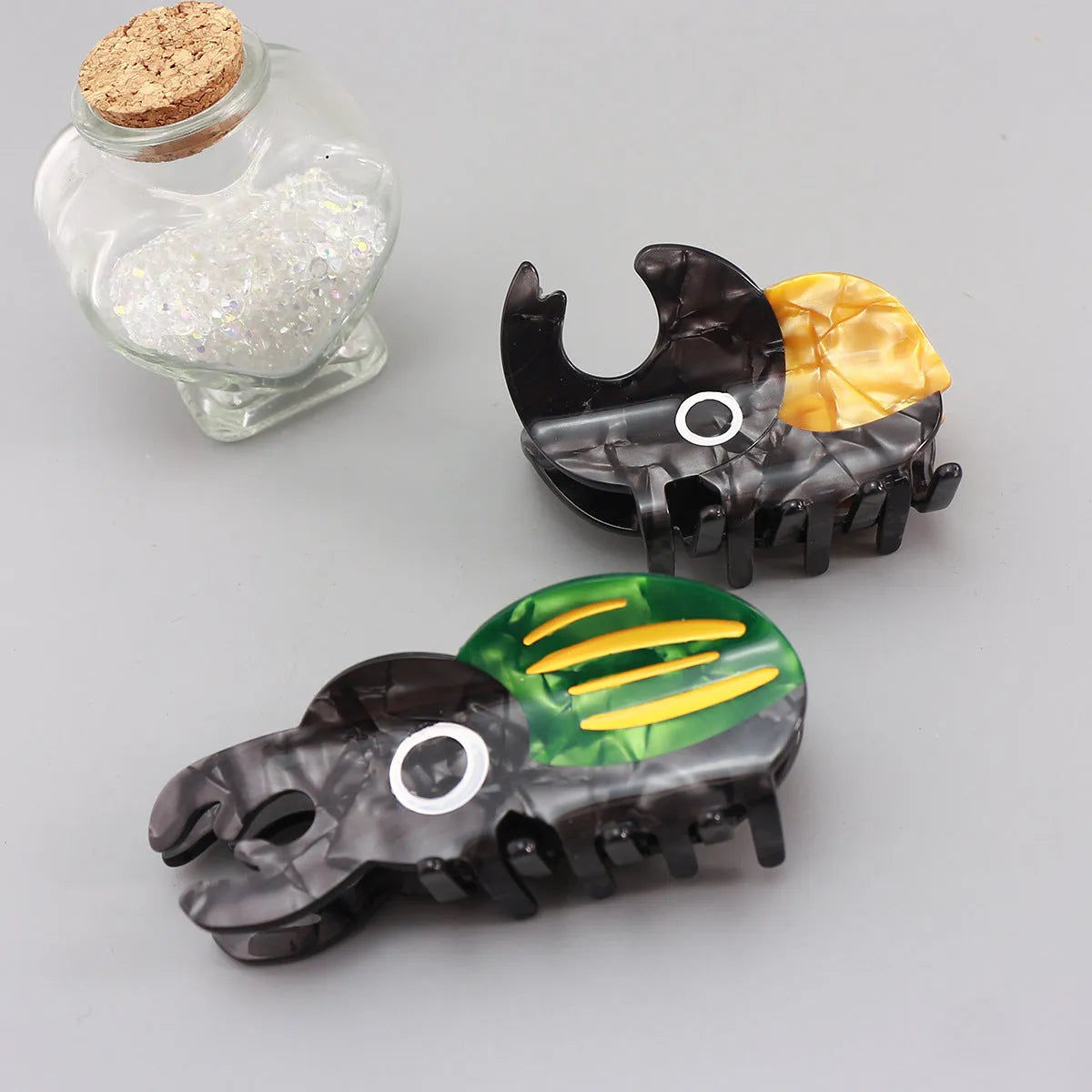 Handmade cellulose acetate beetle grip accessory with cartoon insect biology design in green or orange colour