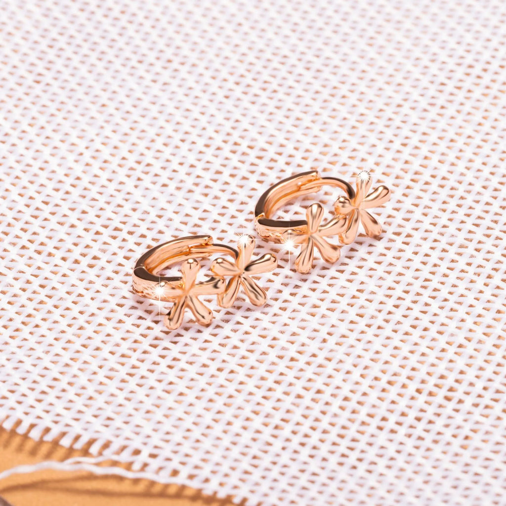 Rose gold circular earrings with a raised waterdrop floral design on a white background.