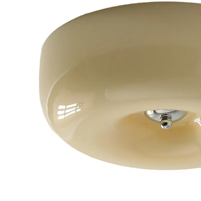 Creamy yellow and white opal shade ceiling light with remote control on a bedroom ceiling.