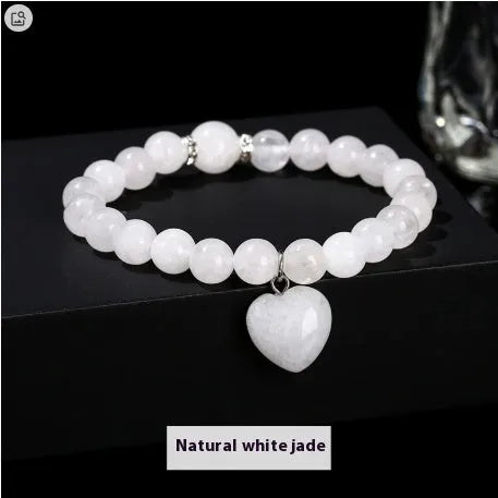 Handmade natural crystal love pendant bracelet with round beads in tiger's eye, aventurine, and white jade on a white background