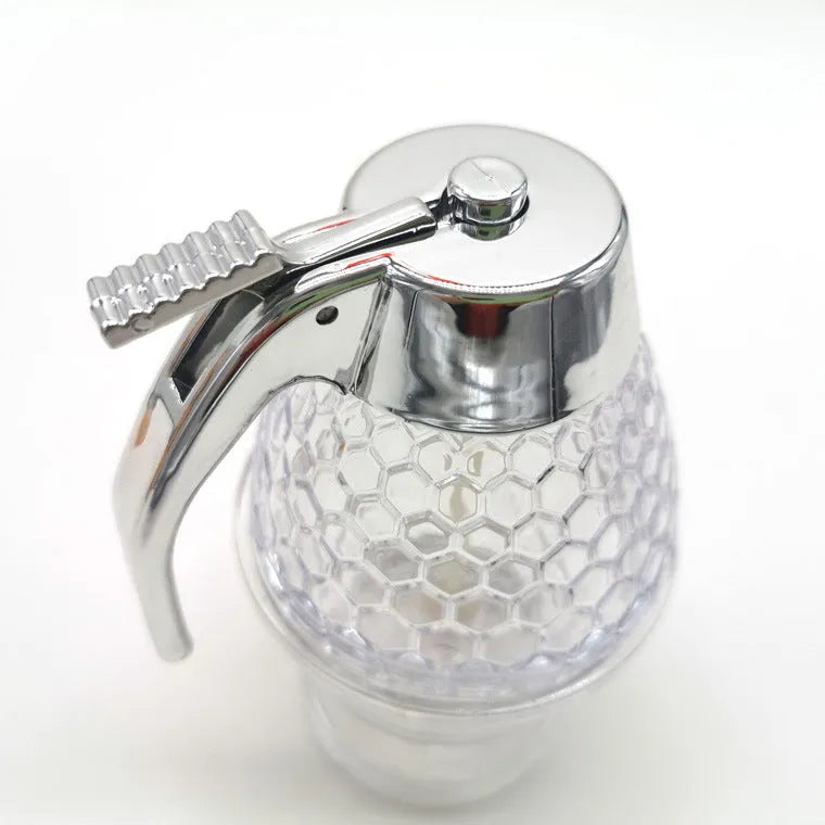 Transparent squeezable honey jar dispenser with 200ml capacity and bee design, sitting on a kitchen counter