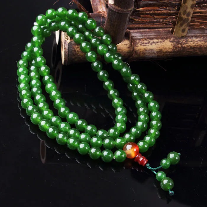 Green jade 8mm bead rosary bracelet with quartz rock material and buddha head on wrist