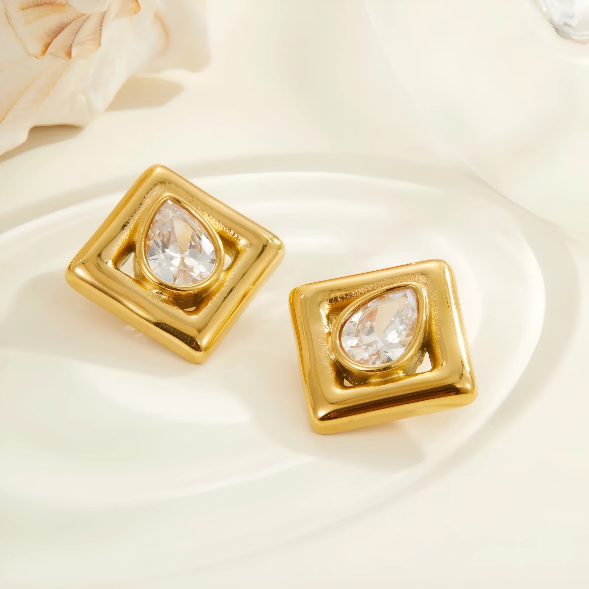 Gold geometric water drop design stud earrings with zircon accents on stainless steel
