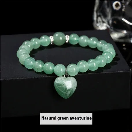 Handmade natural crystal love pendant bracelet with round beads in tiger's eye, aventurine, and white jade on a white background