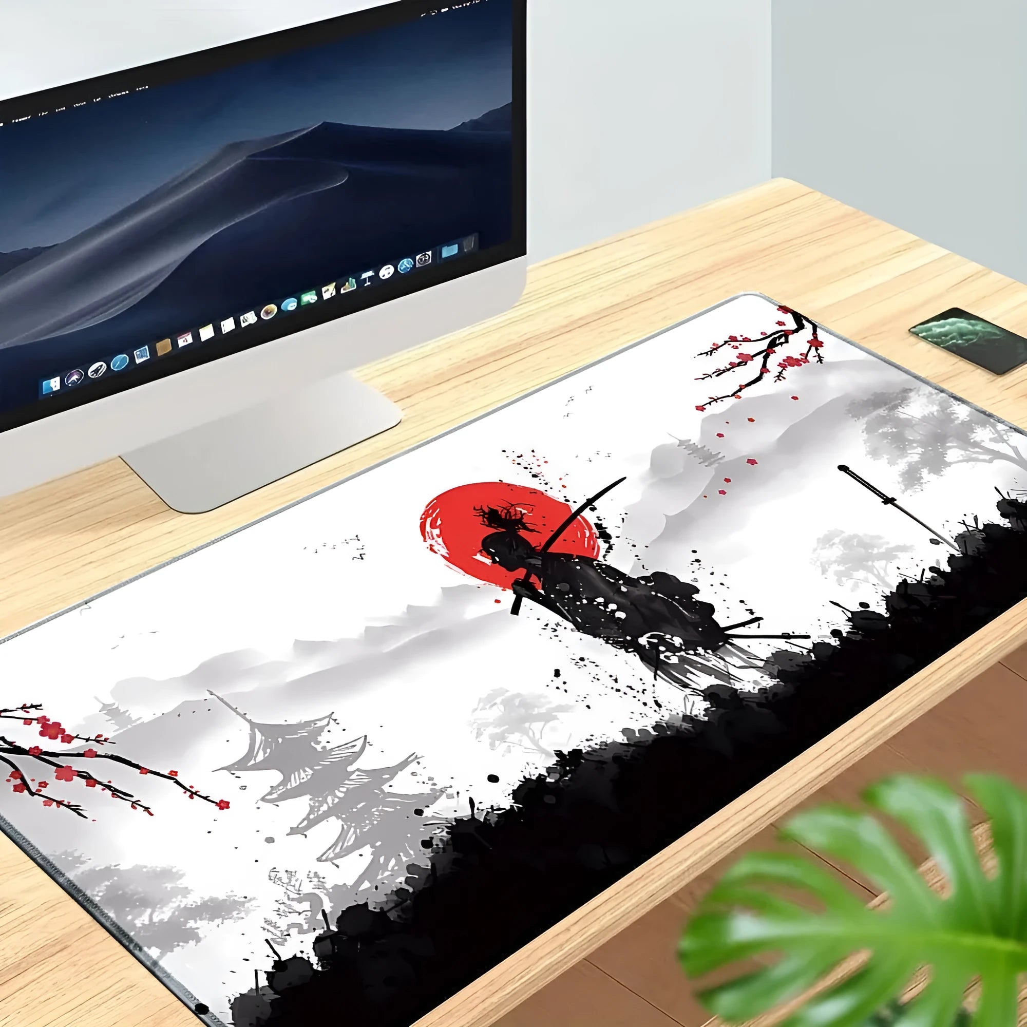 Large black gaming mouse pad with Japanese samurai warrior print and non-slip rubber base on a wooden desk.