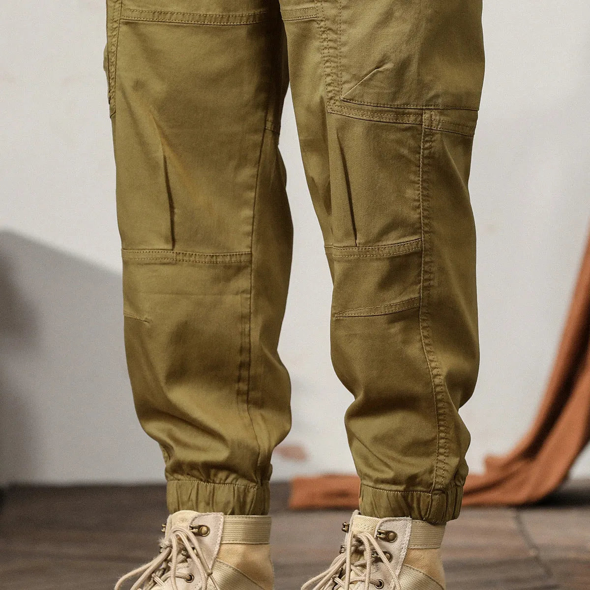 Men's khaki cotton harem pants with ankle bands and a loose, tapered fit.