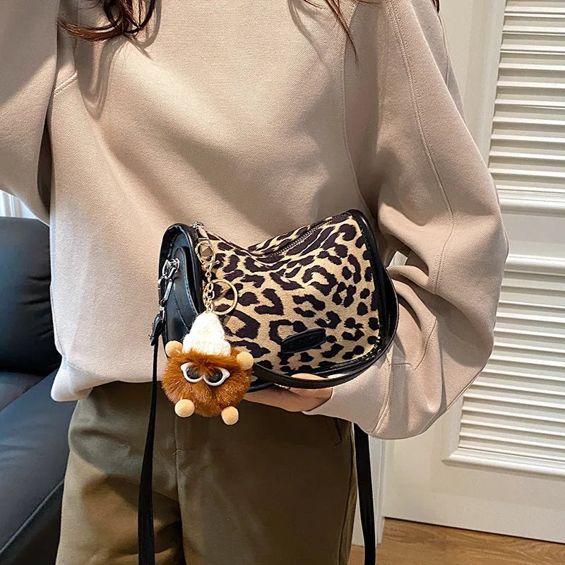 High-textured PU messenger bag with leopard print, horizontal square shape, and decorative pendant