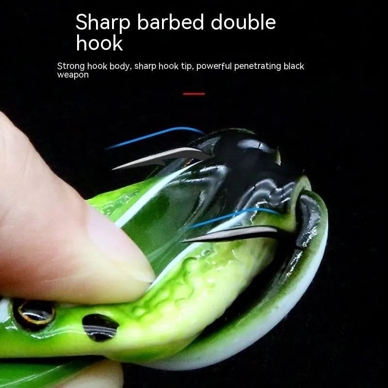 Artificial frog fishing lure with snake head design and double treble hooks in grass green colour