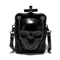 Black square crossbody bag with embossed skull design and metal chain strap against dark background