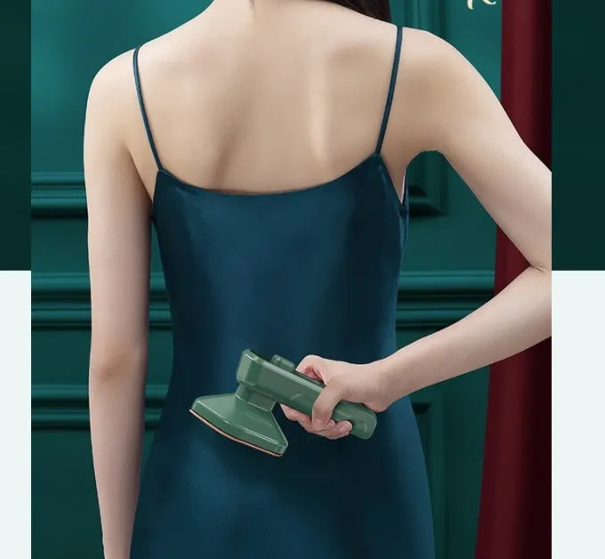 Dark green portable hand-held steam iron with ceramic panel, front view showing sharp corner design and compact size