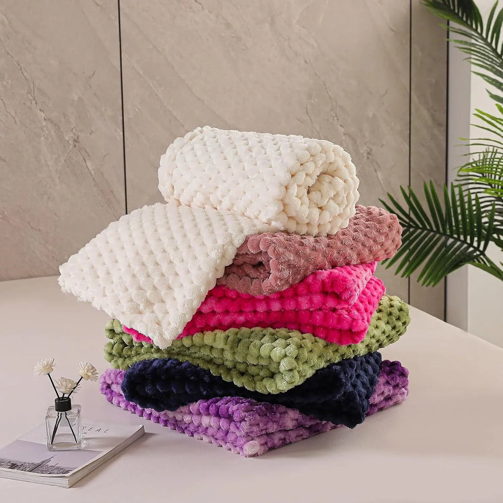 Soft camel-coloured plaid children's blanket folded on a wooden chair.