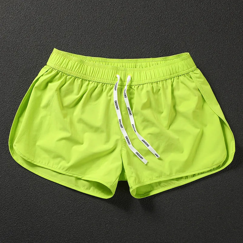Men's loose elastic waist beach shorts in orange, fluorescent green, or black on a size chart.