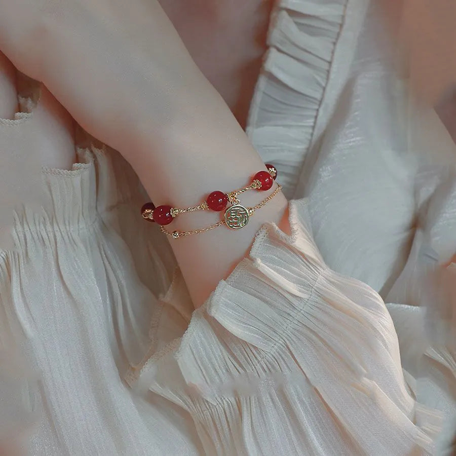 Red agate and alloy double-layer women's bracelet with Hongma blessing card charm on an adjustable fastening.