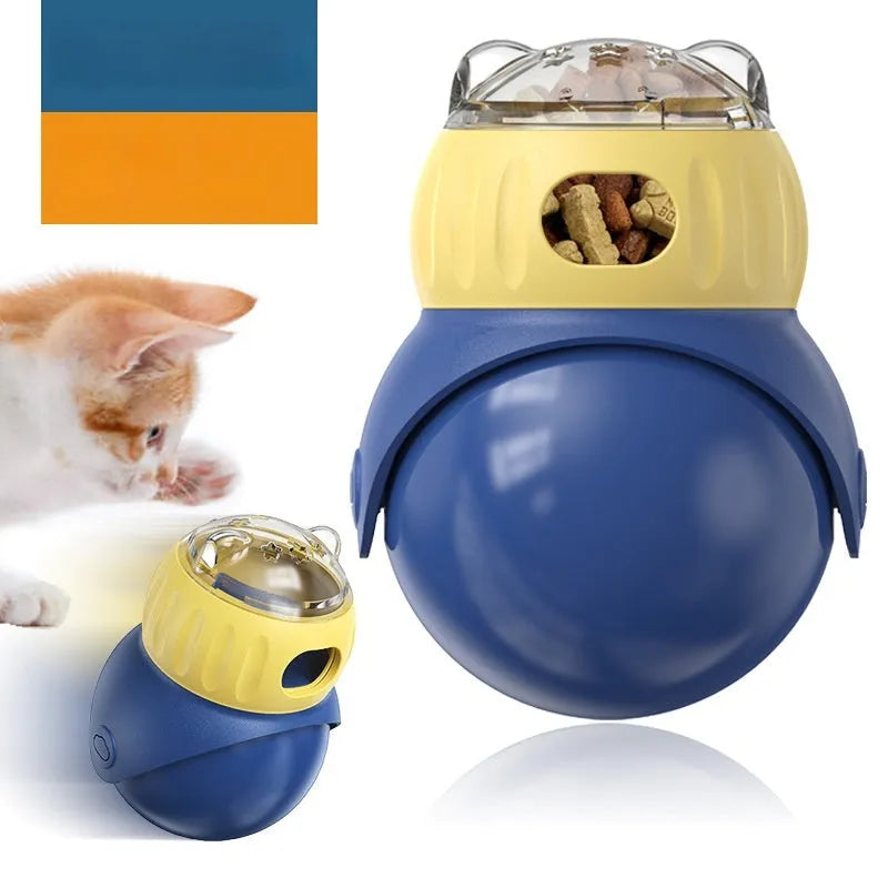 Yellow and blue plastic tumbler owl cat puzzle feeder toy on a wooden floor.