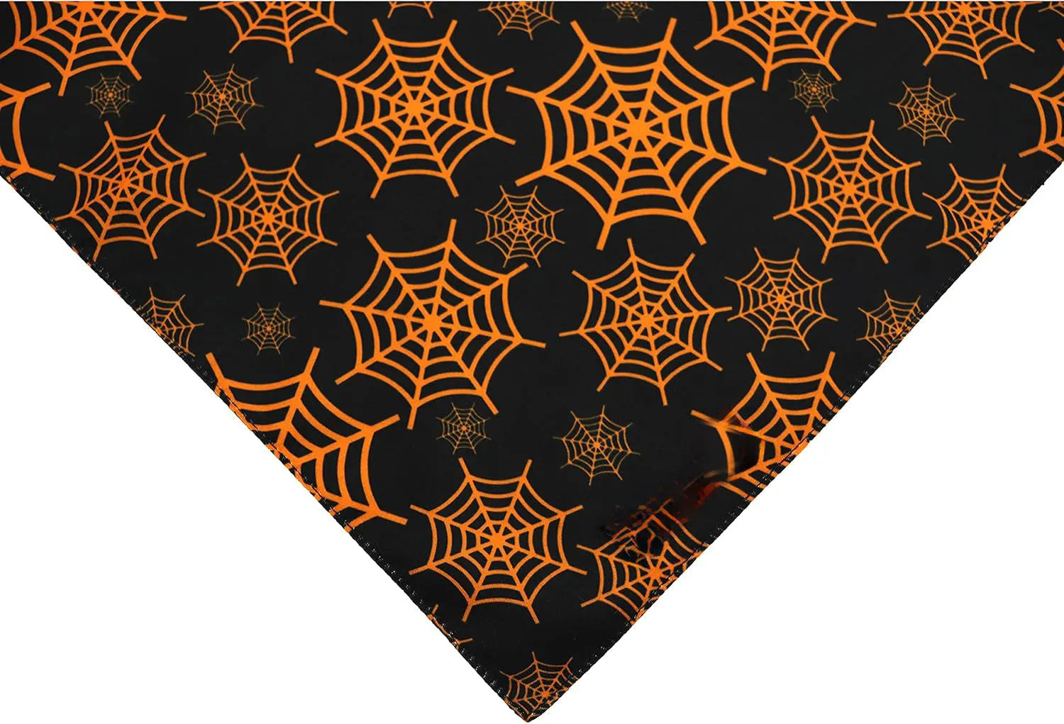 Black and orange reversible Halloween dog bandana with pumpkin and spider web patterns, showing adjustable neck strap