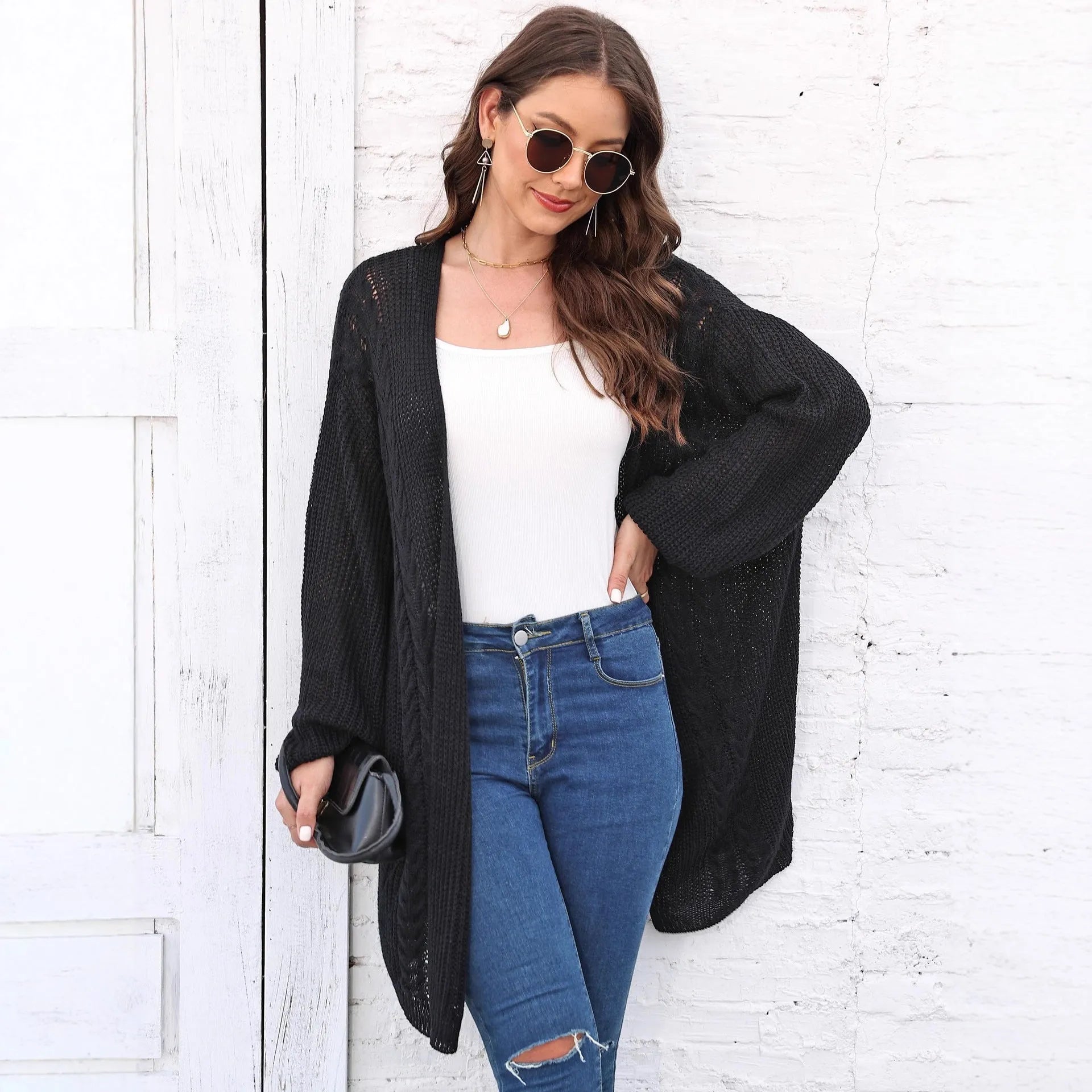 Women's loose fit acrylic sweater coat cardigan in a solid colour on a hanger.