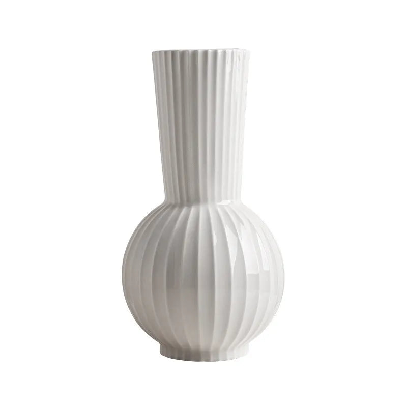 White ceramic ball vase with blue stripes, a silk blue orchid, on a wooden table.
