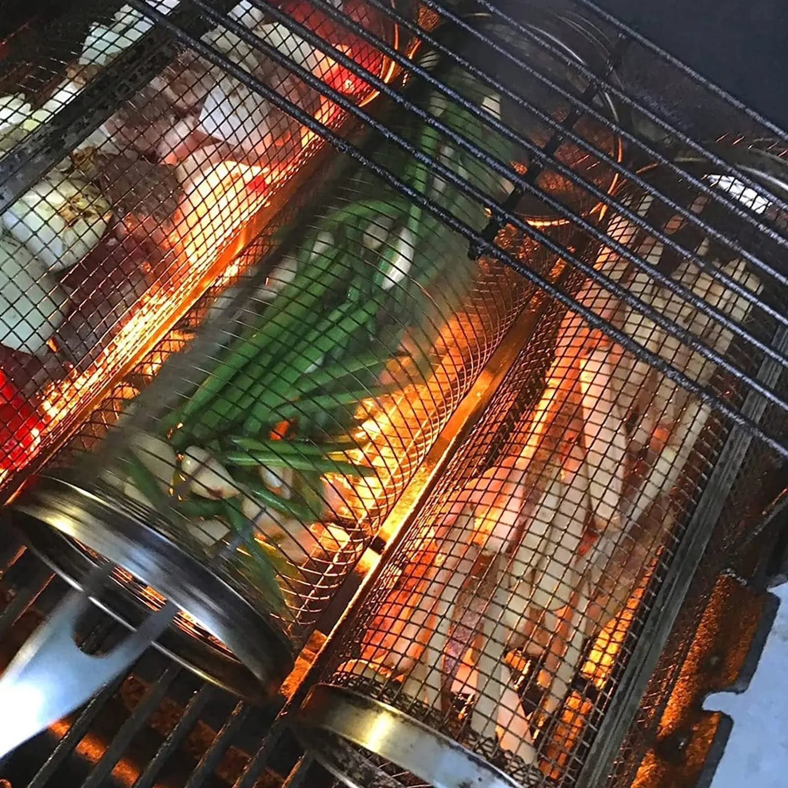 Round stainless steel rolling barbecue grilling basket with mesh sides and a hook, shown with assorted vegetables inside.