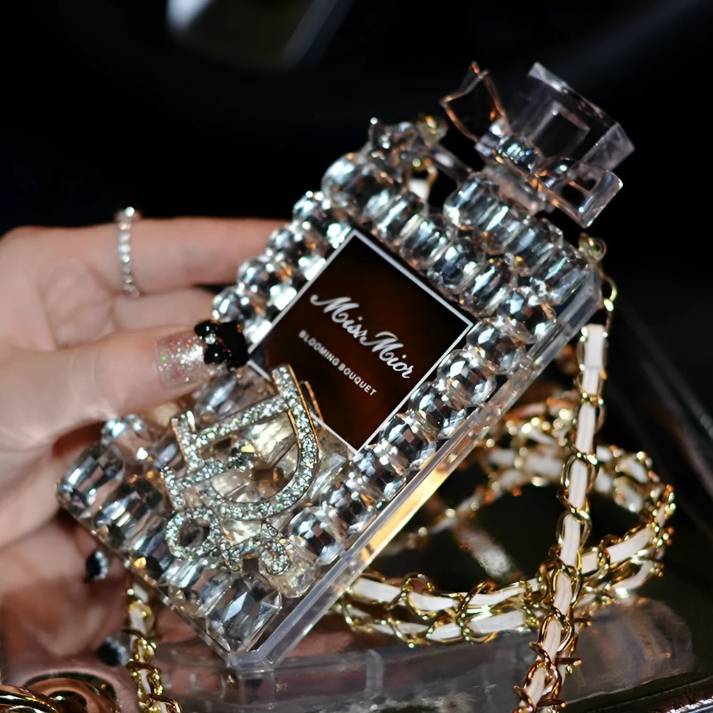 Perfume bottle and bow design iPhone case with metal chain, in matte black TPU, shown fitted on an iPhone.