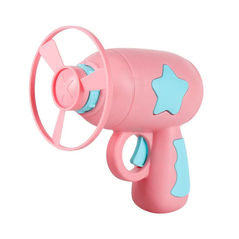Blue plastic flying saucer launcher toy with LED-lit discs on a yellow target board.
