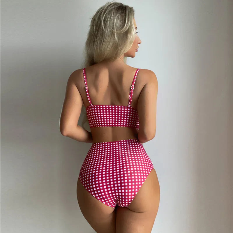 Women's rose red plaid high-waisted bikini set with a split design on the briefs, laid flat.