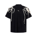 Black loose fit short sleeve t-shirt with padded shoulders and decorative rivet ribbon detail.