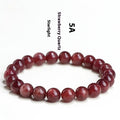 Geometric bead strawberry quartz bracelet in Starlight colour on a wrist, showing size options.